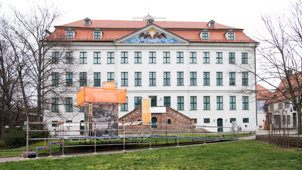 View of the Historic Orphanage with the base station of the open-air exhibition on the meadow.