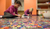 Zwei Kinder lösen auf dem Fußboden ein Sprachpuzzle. 