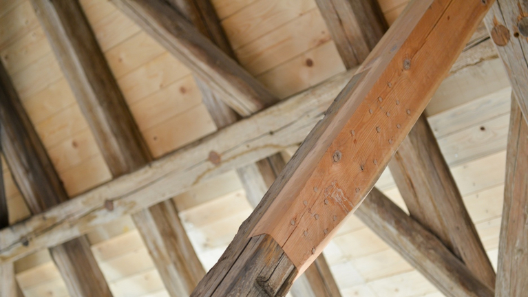 In one beam of the roof truss, defective wood was replaced with wood from the construction period of the Great Barn, cut exactly to fit the damaged area.