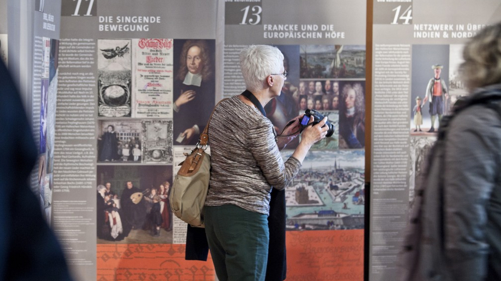 Eine Frau besichtigt die Wanderausstellung Hallescher Pietismus und Reformation in der Vertretung des Landes Sachsen-Anhalt in Berlin