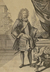 Ein Mann mit Perücke steht auf einer Terrasse an einem verzierten Tisch, darauf eine Krone 