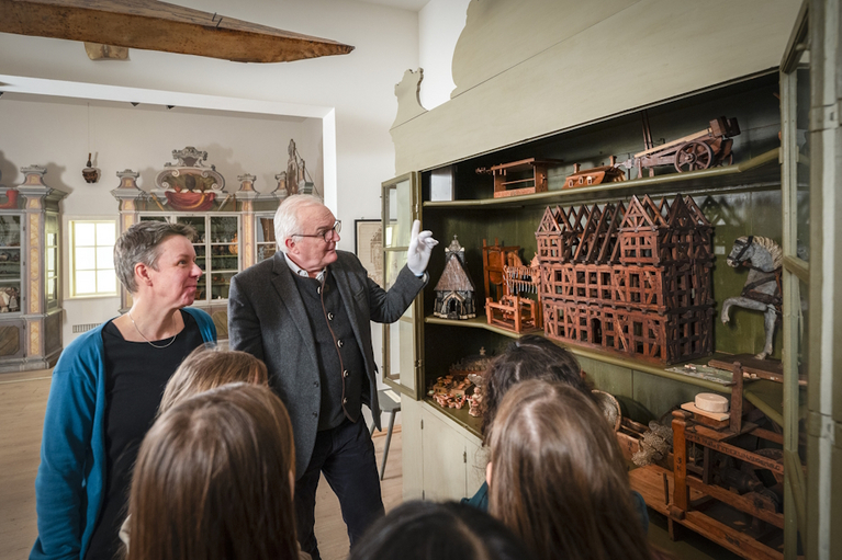 Foundation Director Müller-Bahlke and Deputy Director von Biela take a look at the historical school model collection with five girls from the After School Centre. 