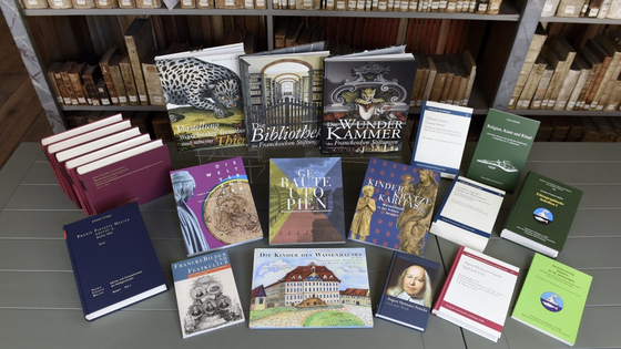 Auf einem Büchertisch liegen eine Auswahl der Publikationen des Verlags der Franckeschen Stiftungen aus: Ausstellungskataloge, wissenschaftliche Schriften, Bildbände und Kinderbücher.