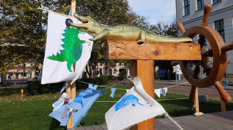 On Franckeplatz there is a ship. A crocodile sits in front of the steering wheel, pennants blow in the wind, a pirate crocodile is painted on the sail.