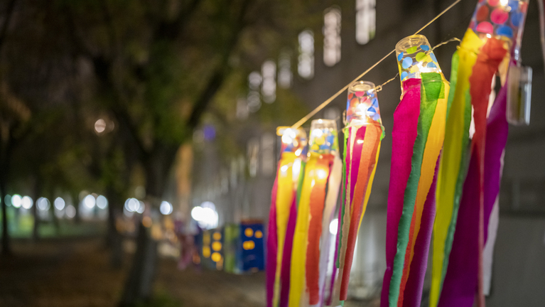 Bunte Laternen hängen im dunklen Lindenhof