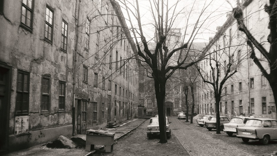 Blick in den Lindenhof mit den stark sanierungsbedüftigen Gebäuden zur rechten und linken Hand sowie unzähligen parkenden Trabanten.