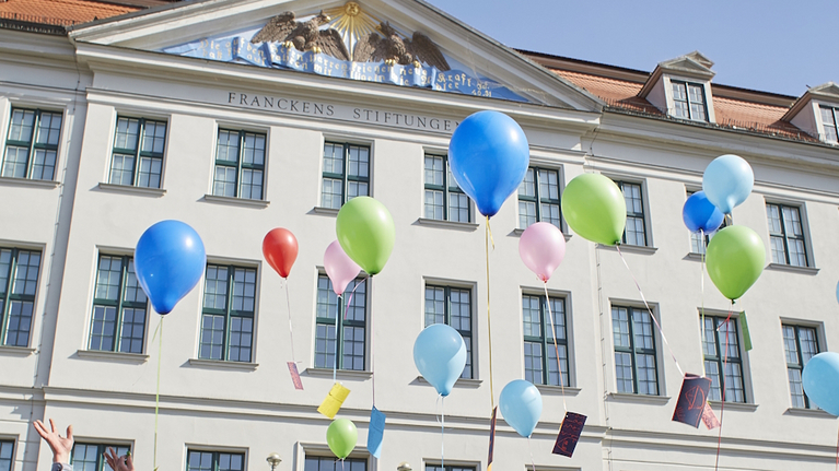 Vor der Fassade des Historischen Waisenhauses steigen Luftballons mit Zeichnungen und Wünschen der Kinder des Krokoseums auf.